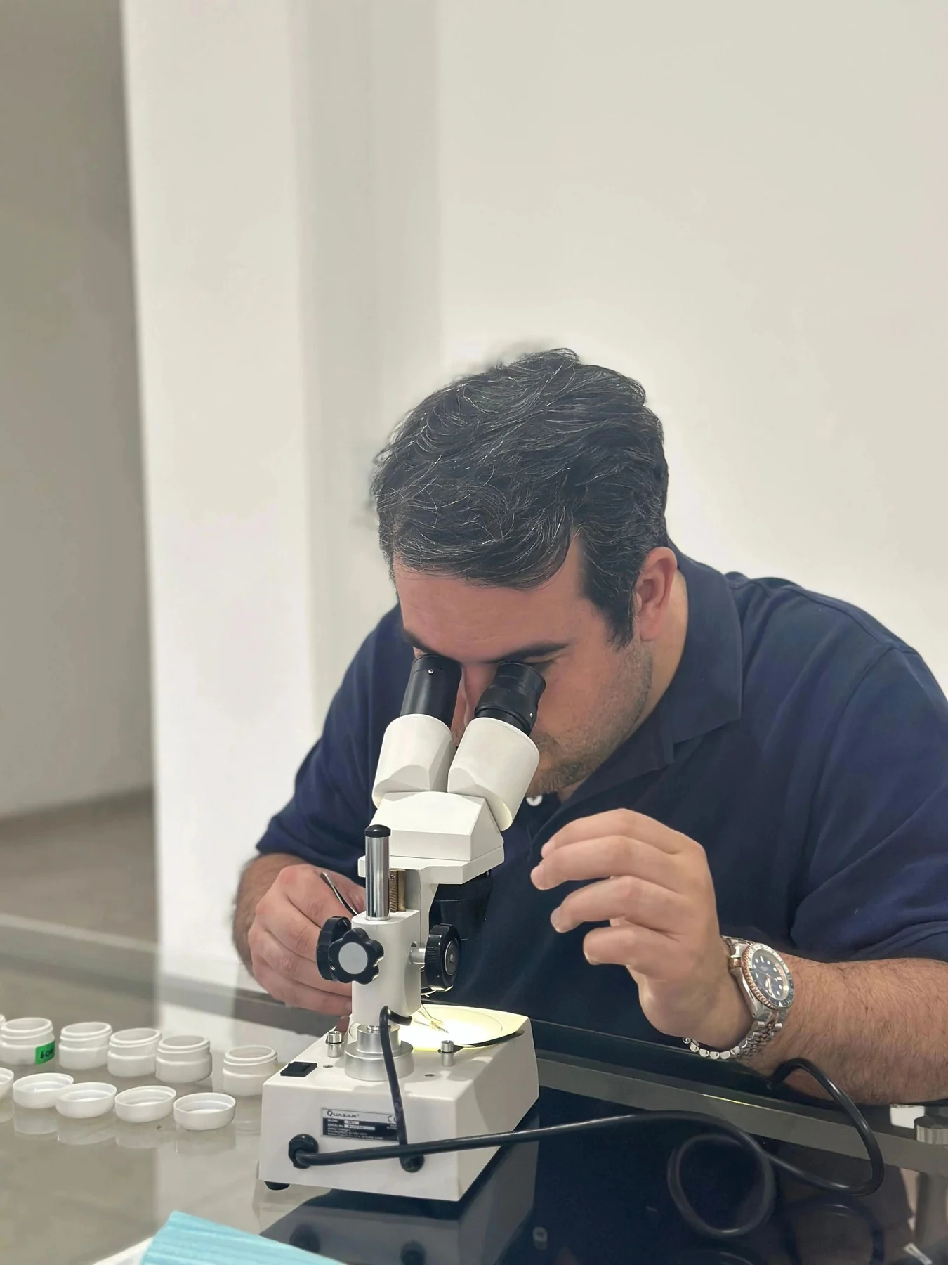 Carlos Cuadrado trabajando con un microscopio en un entorno de análisis forense